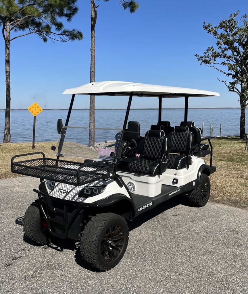 a white golf cart parked near Choctawhatchee Bay in Walton County, FL